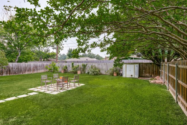 Fenced backyard featuring a storage shed and a patio area | Image 24
