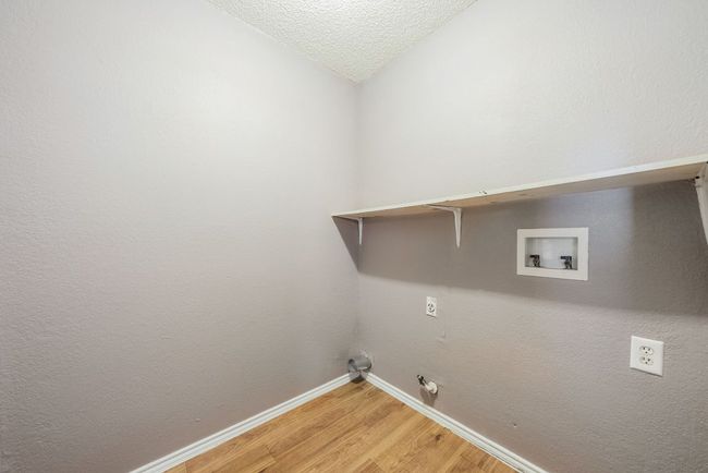 Washroom featuring hookup for a gas dryer, light wood-style floors, washer hookup, and a textured ceiling | Image 18