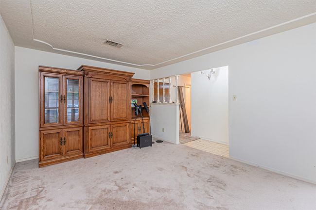 Spare room featuring visible vents, light carpet, and a textured ceiling | Image 7
