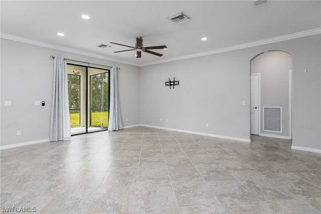 Tiled empty room featuring ceiling fan and ornamental molding | Image 8