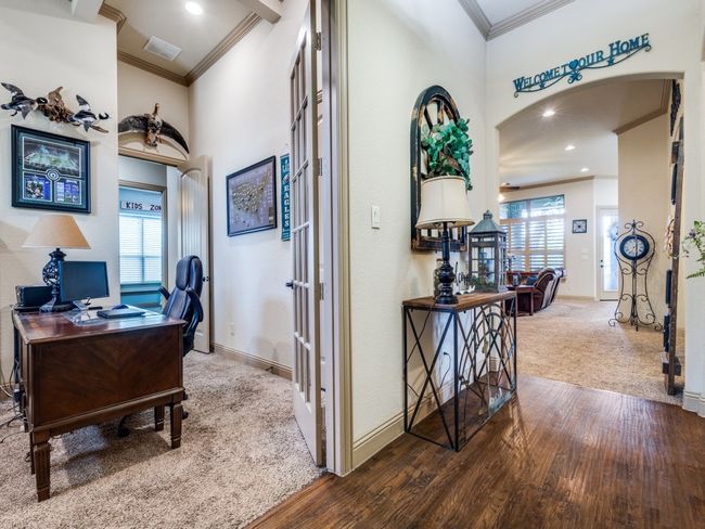 Bedroom or Home office featuring ornamental molding, arched walkways, wood finished floors, baseboards, and carpet floors | Image 5