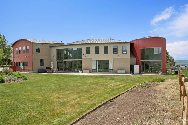 Rear view of property featuring a yard, stucco siding, and a standing seam roof | Image 39