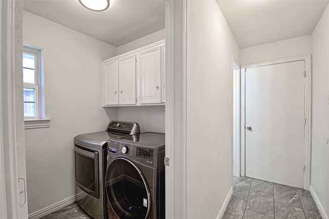 Washroom featuring washing machine and clothes dryer, cabinet space, and light marble finish flooring | Image 27