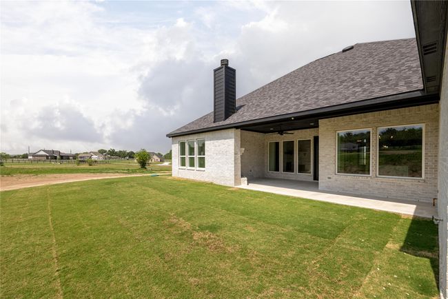 Rear view of house with a lawn, ceiling fan, and a patio area | Image 37