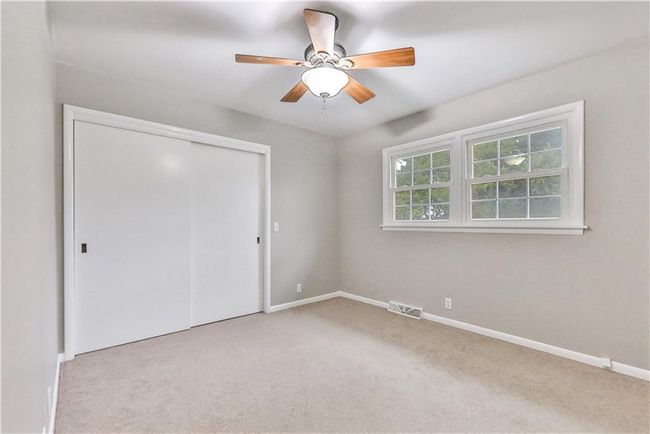 Unfurnished bedroom featuring ceiling fan, a closet, and light colored carpet | Image 13