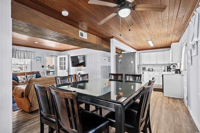Dining room with wooden ceiling, light wood-style flooring, ceiling fan, and crown molding | Image 6