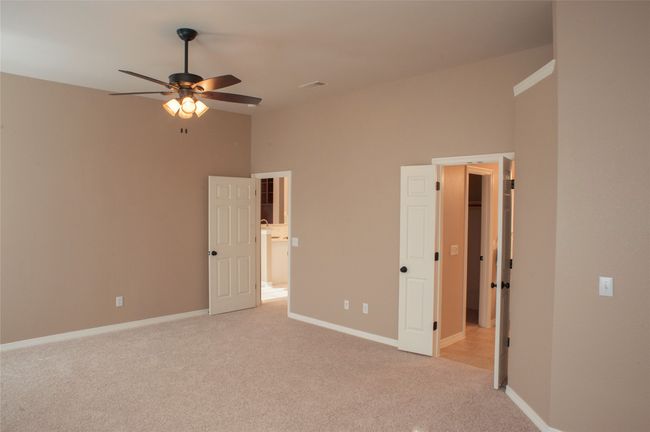 Unfurnished bedroom with light carpet, baseboards, and ceiling fan | Image 11