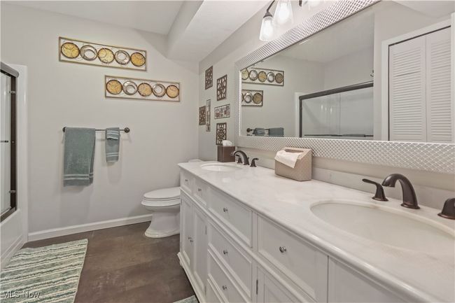 Bathroom featuring baseboards, a shower with shower door, toilet, and a sink | Image 19
