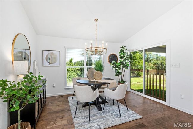 Dining area with lofted ceiling, a chandelier, dark wood-style floors, and baseboards | Image 16