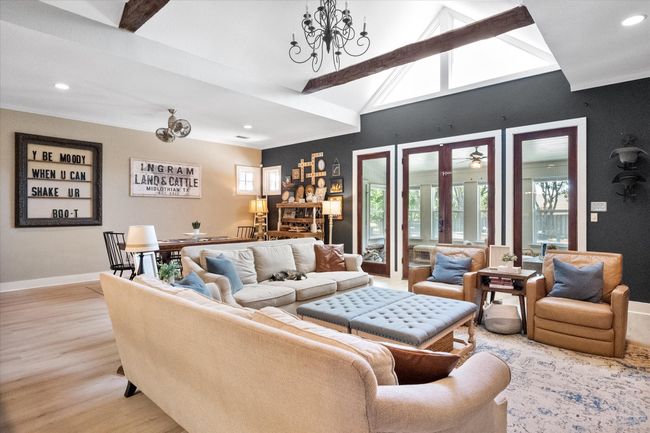 Living room with light wood finished floors, a chandelier, recessed lighting, baseboards, and ornamental molding | Image 5