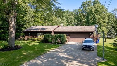 View of front of property with attached, heated garage and extra wide concrete driveway | Image 1