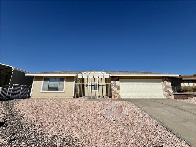 Ranch-style home with an attached garage, concrete driveway, and stone siding | Image 12