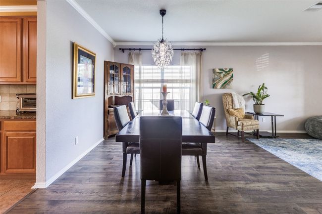 Dining area with a chandelier, crown molding, dark wood-type flooring, and baseboards | Image 16