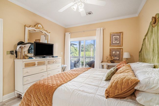 Bedroom featuring access to exterior, crown molding, wood finished floors, and ceiling fan | Image 14
