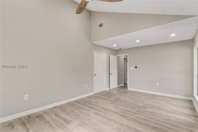 Spare room featuring light hardwood / wood-style flooring, high vaulted ceiling, and ceiling fan | Image 8