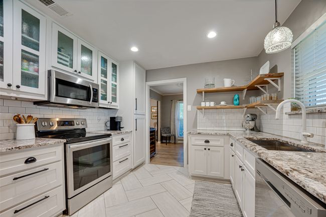 Kitchen with stainless steel appliances, white cabinets, tasteful backsplash, plenty of natural light, and recessed lighting | Image 14