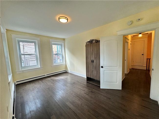 Unfurnished room with a baseboard heating unit and dark hardwood / wood-style flooring | Image 9