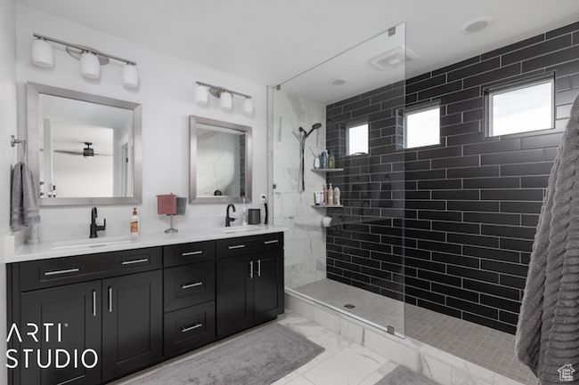 Bathroom featuring double vanity, tiled shower, marble finish floor, and a sink | Image 34