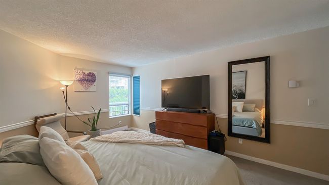 Bedroom with a textured ceiling, baseboards, and carpet floors | Image 11