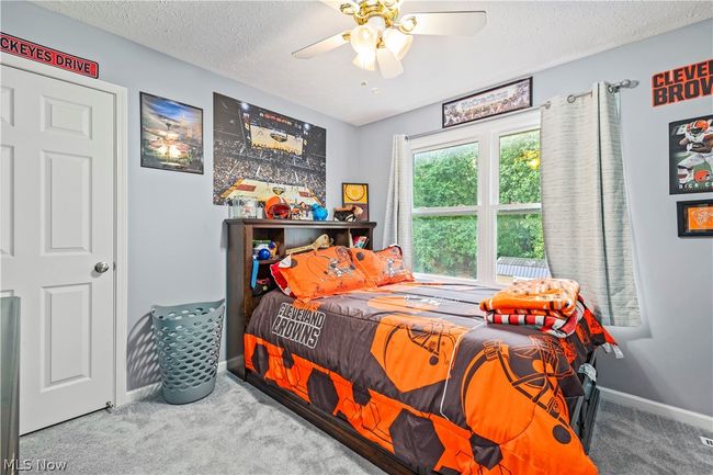 Carpeted bedroom with ceiling fan and a textured ceiling | Image 26
