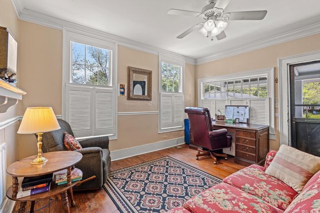 Office space featuring healthy amount of natural light, ornamental molding, wood finished floors, and a ceiling fan | Image 38