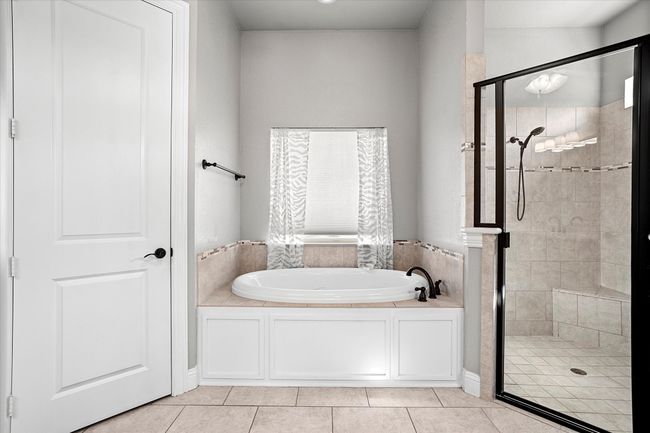Full bathroom featuring a bath, a stall shower, and tile patterned flooring | Image 19