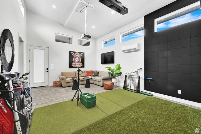 Living area featuring a wall mounted air conditioner, a high ceiling, baseboards, recessed lighting, and wood finished floors | Image 56