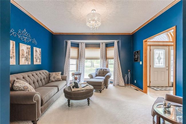Living room with crown molding, a textured ceiling, and an inviting chandelier | Image 19