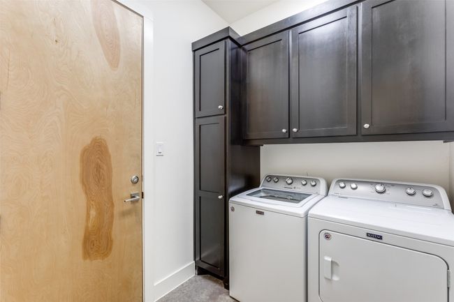 Clothes washing area with washing machine and dryer, cabinet space, and baseboards | Image 18