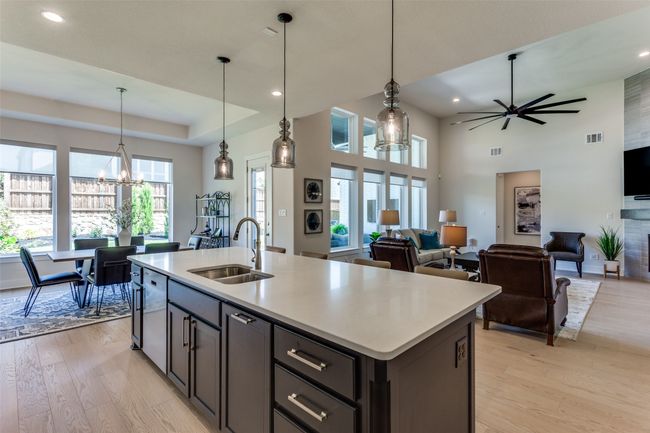 Kitchen with light wood finished floors, light countertops, a center island with sink, recessed lighting, and open floor plan | Image 15