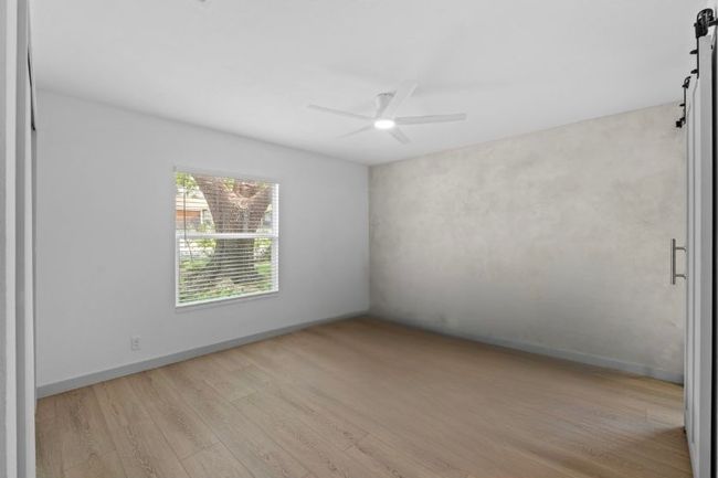 Hand trowled concrete wall installation, new large window, and custom closet built ins. | Image 17