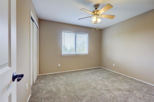 Unfurnished bedroom featuring carpet flooring, a closet, and a ceiling fan | Image 17