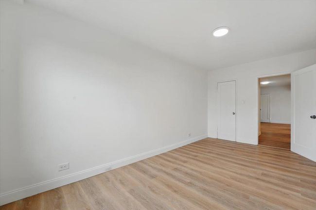 Unfurnished bedroom with light wood-style flooring and baseboards | Image 20