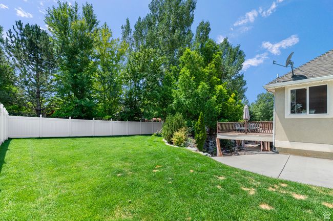 Fenced yard with a patio area and a wooden deck | Image 44