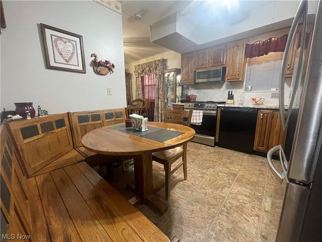 Kitchen featuring light tile flooring, stainless steel appliances, and backsplash | Image 14