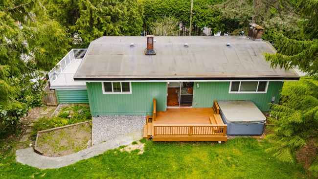 Rear view of property with a wooden deck, a lawn, and fence | Image 38