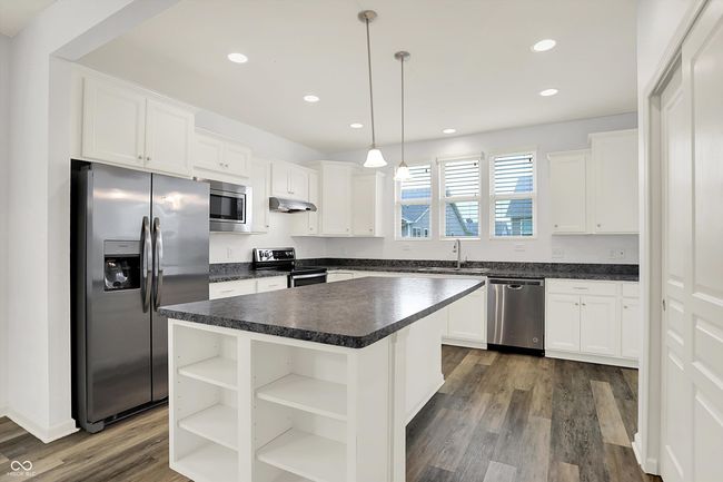 kitchen featuring appliances with stainless steel finishes, dark countertops, open shelves, white cabinets, and recessed lighting | Image 6