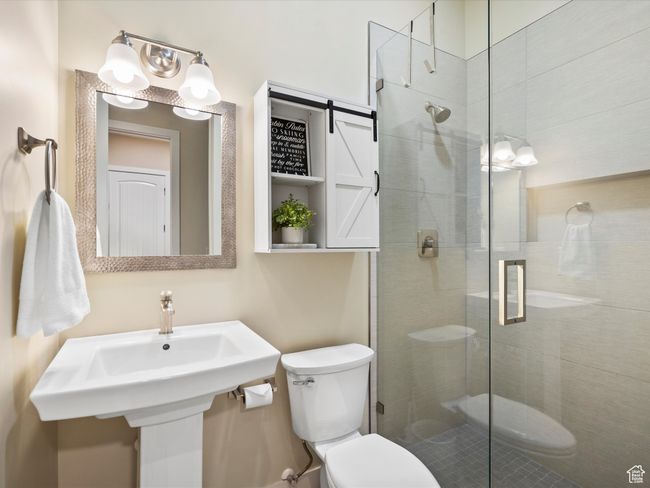 Bathroom with toilet, a stall shower, and a sink | Image 27