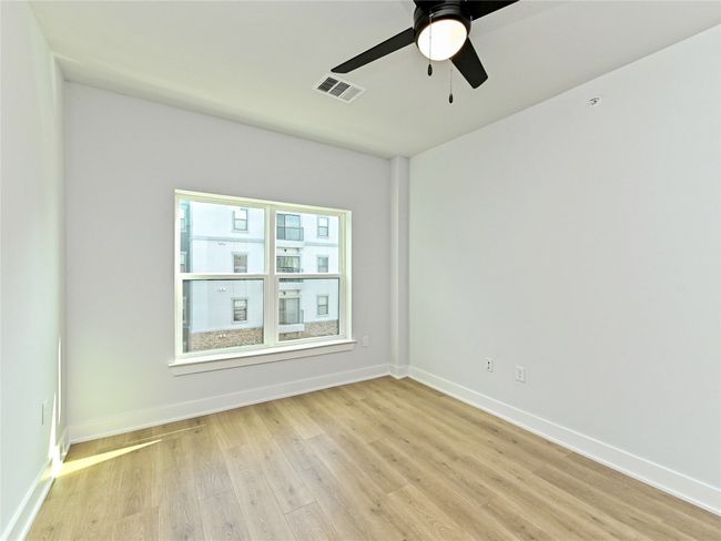 Empty room featuring light wood-type flooring, baseboards, and a ceiling fan | Image 9