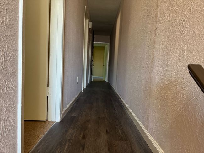 Hallway featuring wood finished floors and a textured wall | Image 11