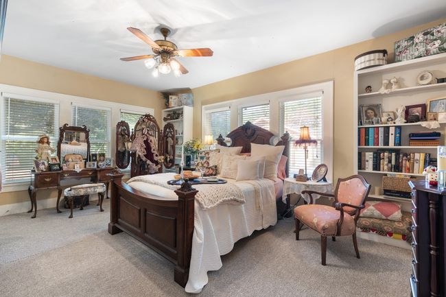 Bedroom featuring light colored carpet, multiple windows, and ceiling fan | Image 24