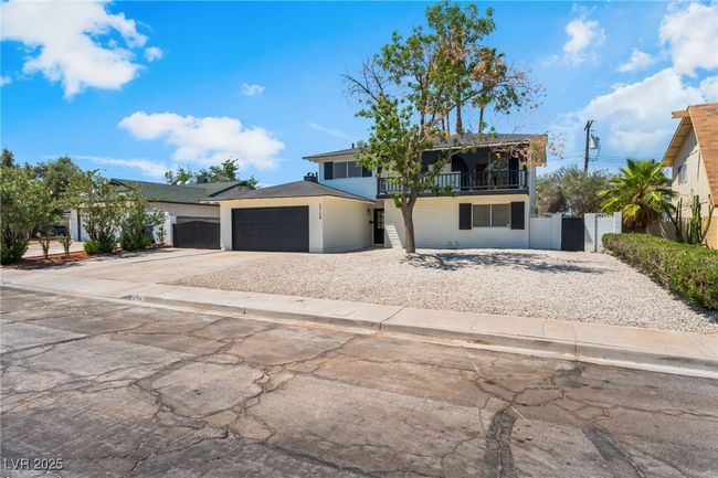 View of front of house featuring a balcony, an attached garage, concrete driveway, and a gate | Image 51