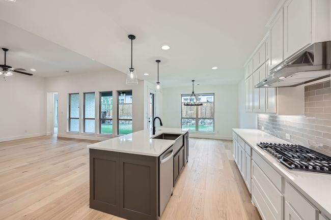 Kitchen with a sink, stainless steel appliances, recessed lighting, under cabinet range hood, and light wood-style floors | Image 10