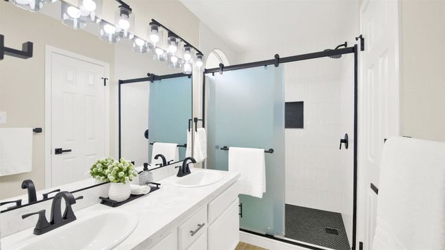 Full bathroom featuring a sink, a shower stall, and double vanity | Image 12