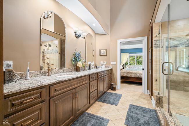 ensuite bathroom with double vanity, connected bathroom, a stall shower, and a sink | Image 45