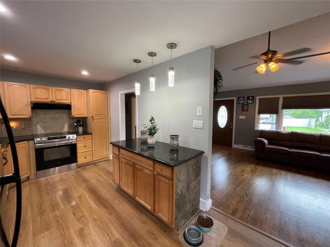 Kitchen with oven, light wood finished floors, under cabinet range hood, a ceiling fan, and recessed lighting | Image 18