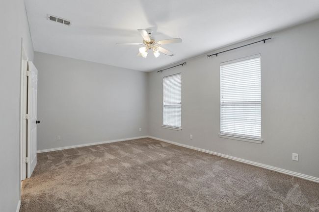 Empty room with ceiling fan and carpet flooring | Image 9