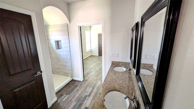 Full bath featuring double vanity, wood finished floors, a sink, and a shower stall | Image 9