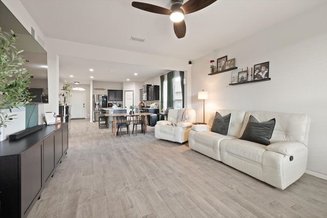 Living area with a ceiling fan, light wood-style flooring, and recessed lighting | Image 18