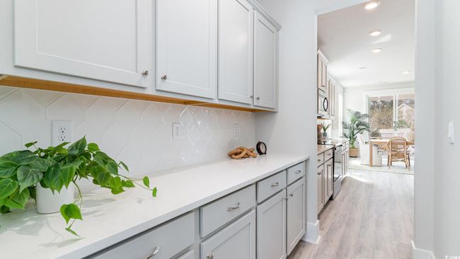 Kitchen with backsplash, light countertops, light wood-style flooring, stainless steel appliances, and recessed lighting | Image 14